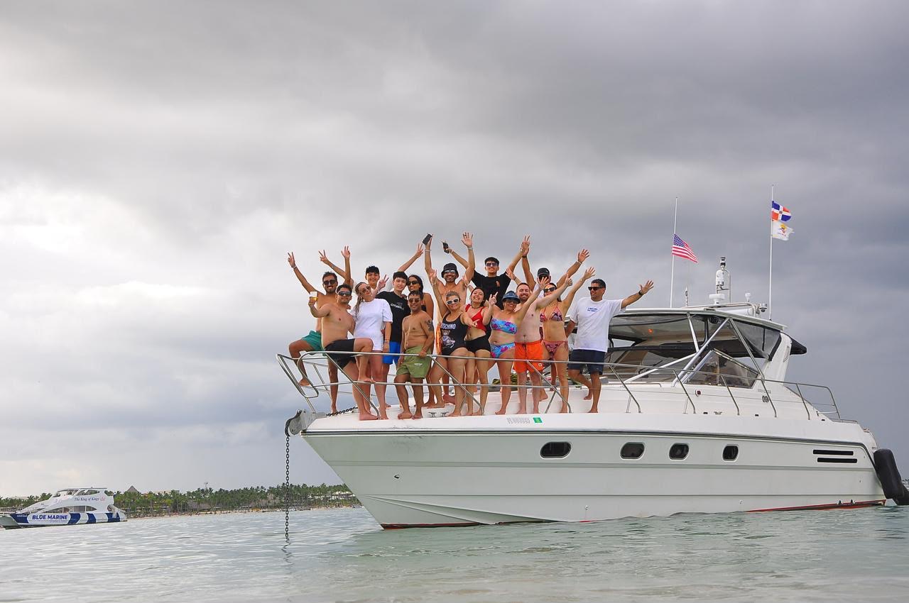 Private motor yacht anchored with a group gathered on the bow