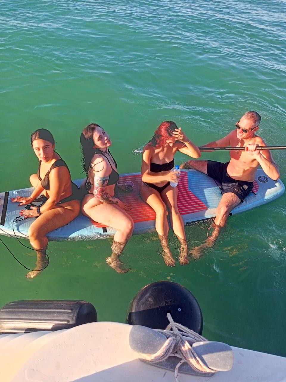 Guests relaxing on a paddleboard in warm late-afternoon light